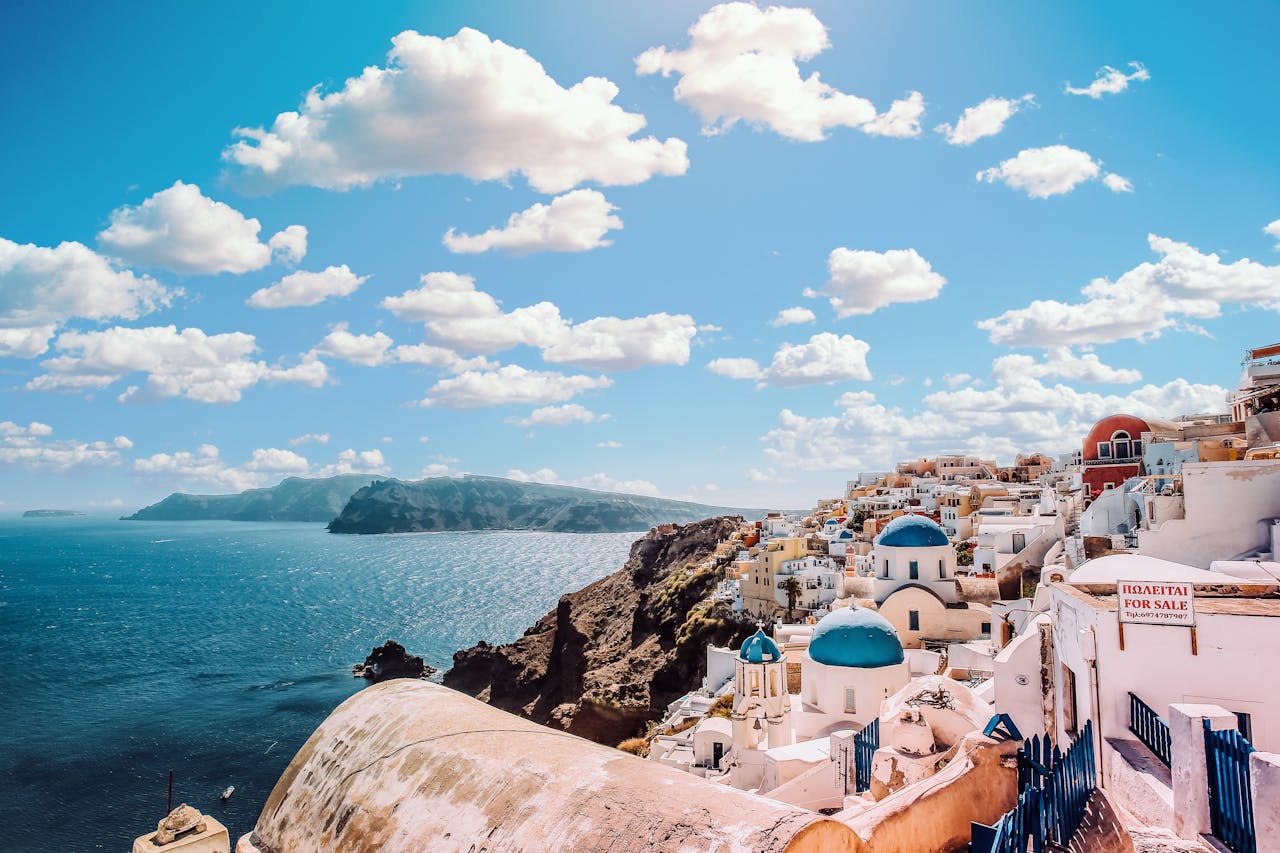 menu-12 Captivating view of Santorini's famous blue-domed buildings under a vibrant sky.